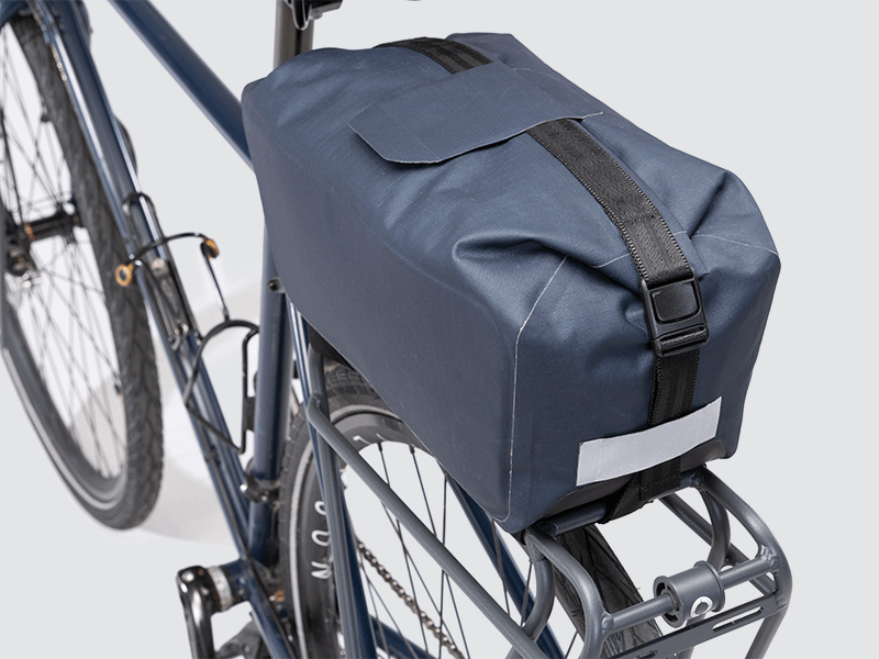 Waterproof Tour trunk bag with integrated attachment, reflective details, and protective base for secure storage.