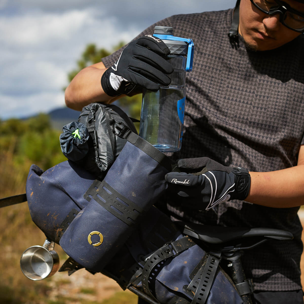 Off-Road Bottle Pouch designed to securely hold a large bottle or snacks, featuring roll top for weather protection and durable fabric for outdoor use.