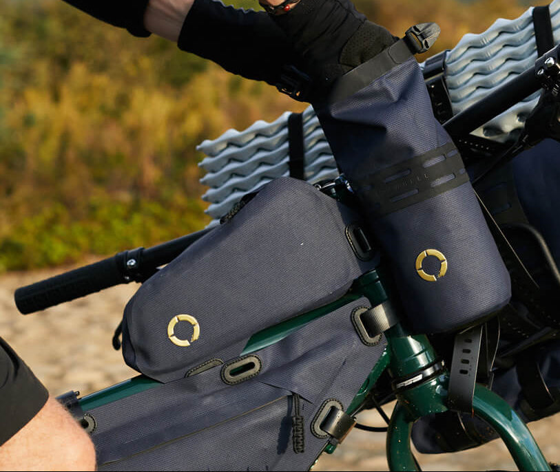 Off-Road Bottle Pouch designed to securely hold a large bottle or snacks, featuring roll top for weather protection and durable fabric for outdoor use.