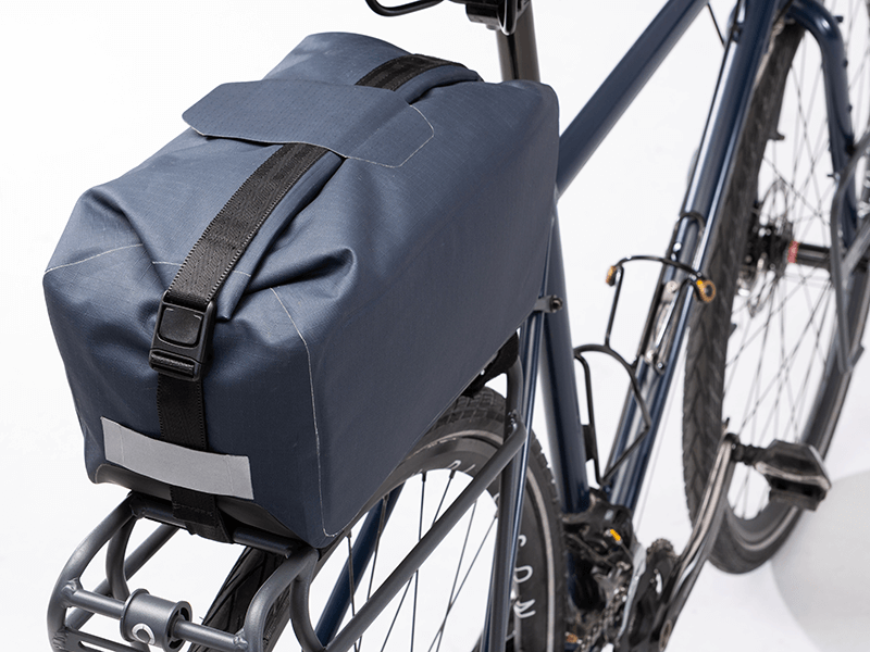 Waterproof Tour trunk bag with integrated attachment, reflective details, and protective base for secure storage.